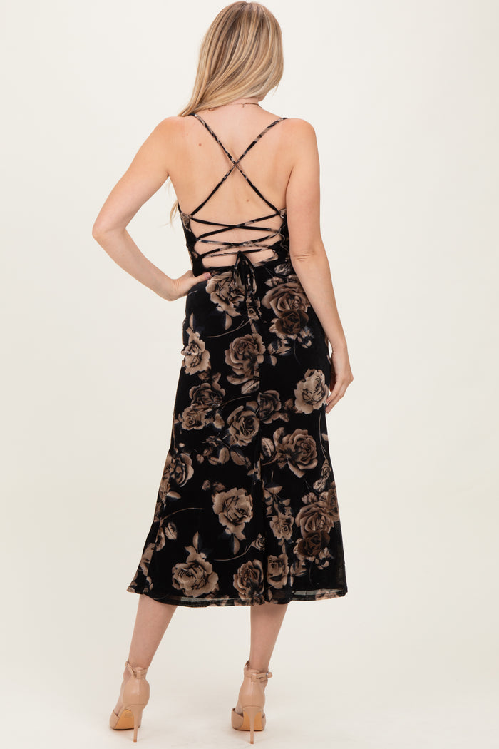 woman wearing a black floral midi dress with crisscross back detailing