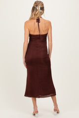 woman wearing a burgundy maternity dress with a halter neck and fitted silhouette, showing her baby bump from the back