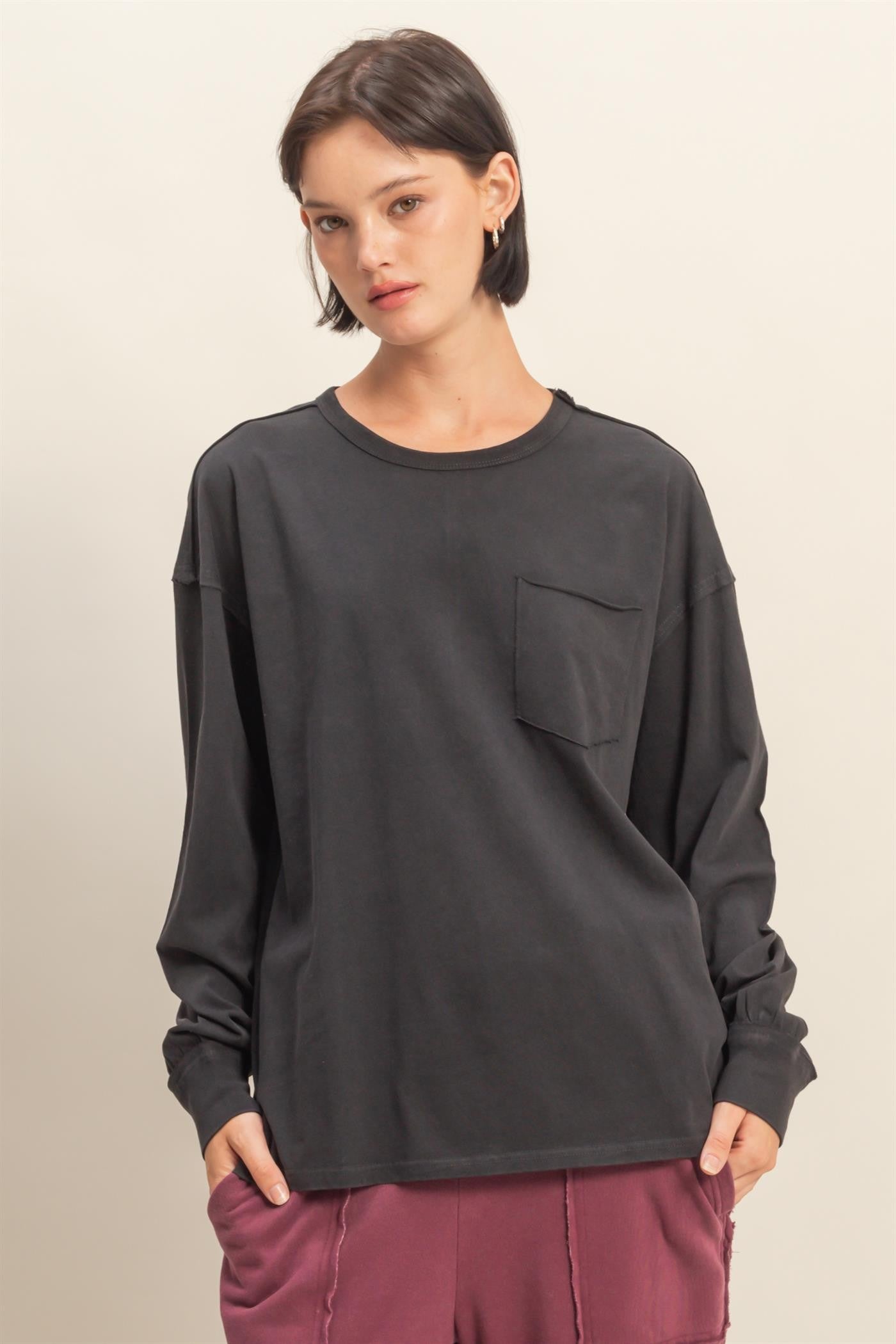 woman wearing a dark gray long sleeve shirt with a front pocket and relaxed fit