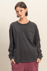 woman wearing a dark gray long sleeve shirt with a front pocket and relaxed fit