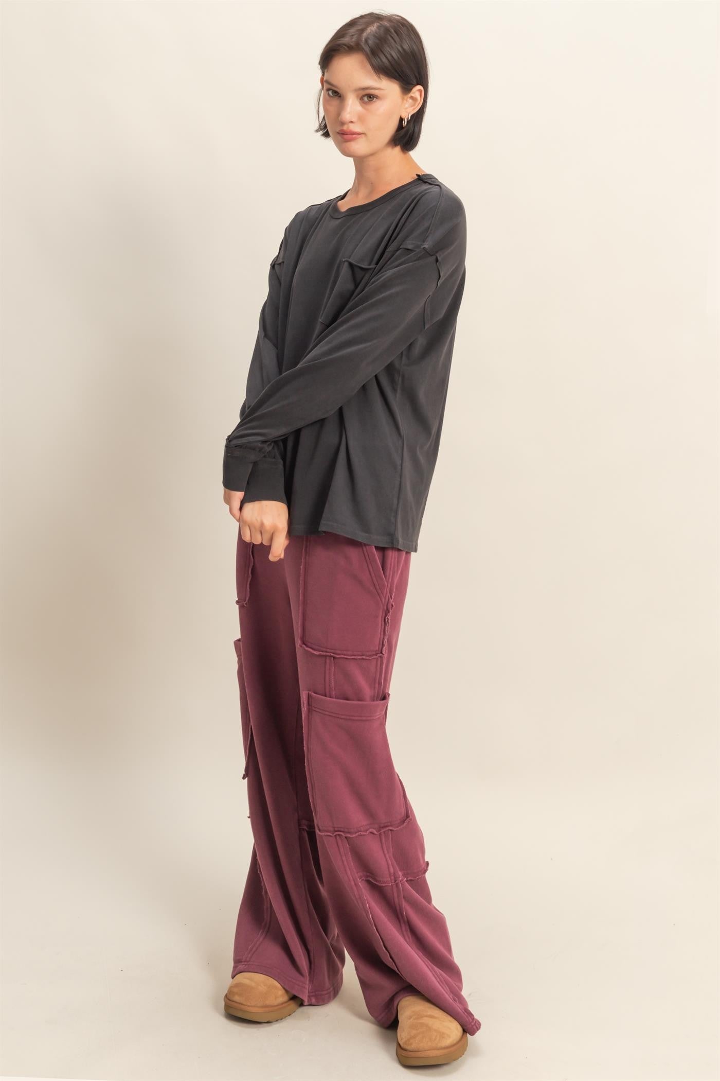 woman wearing a black long sleeve shirt and burgundy wide-leg cargo pants