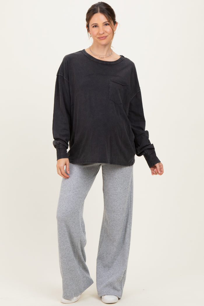 woman wearing a black long sleeve oversized maternity top with a pocket and gray wide-leg maternity pants