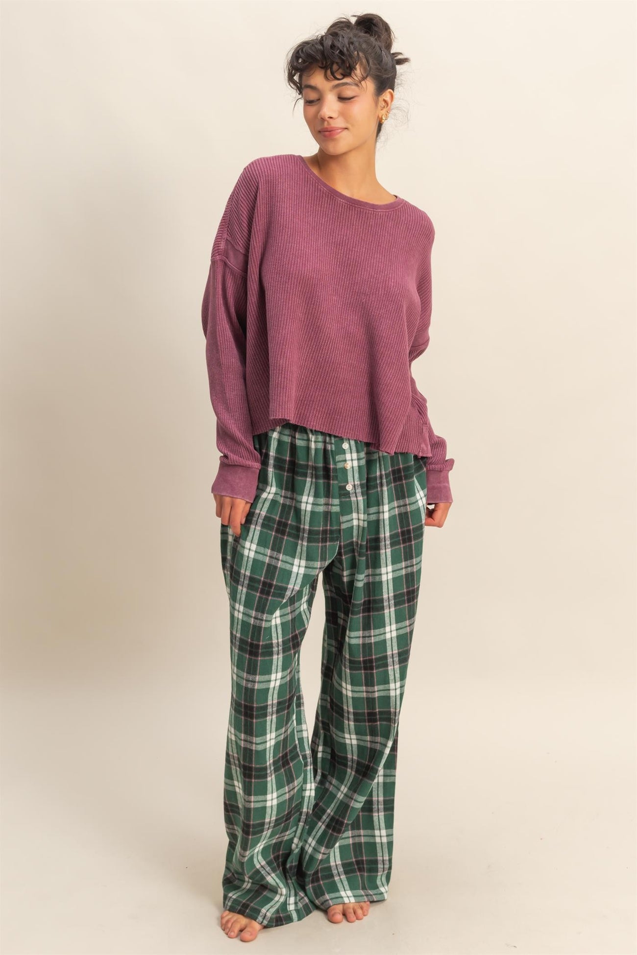 woman wearing a purple oversized ribbed sweater and green plaid lounge pants