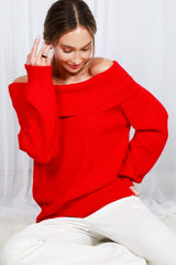 woman wearing a red off-the-shoulder sweater with wide sleeves and a relaxed fit, paired with white pants