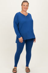 woman wearing a royal blue long sleeve maternity top and matching leggings, showing her baby bump