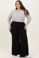 woman wearing a gray long sleeve henley top and black flowy plus size pants with a wide waistband
