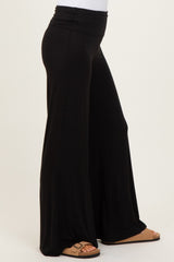woman wearing black wide-leg lounge pants with a high waistband and sandals
