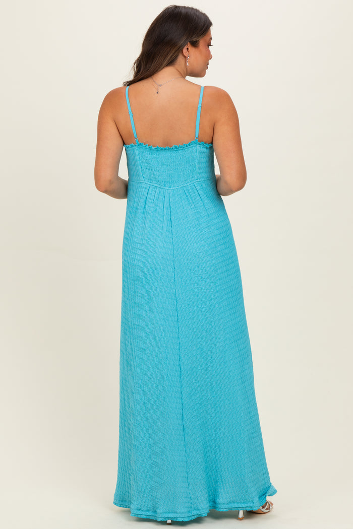 woman wearing a light blue maternity maxi dress with a smocked back and adjustable spaghetti straps