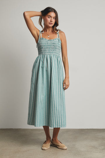 woman wearing a teal and white striped midi dress with smocked bodice and tie straps