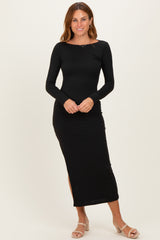 woman wearing a black long sleeve midi dress with side slits and a fitted silhouette