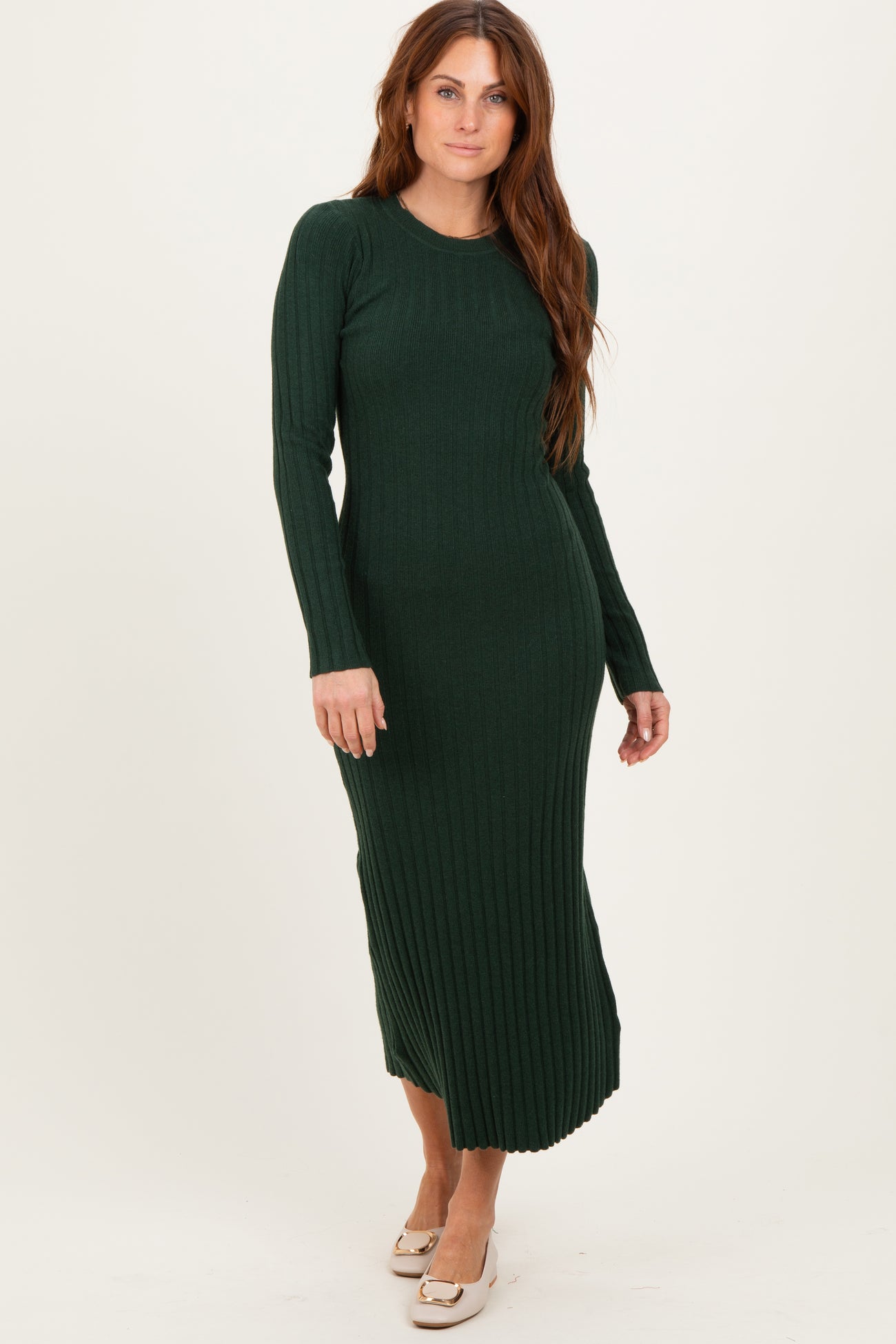 woman wearing a long green ribbed knit dress with long sleeves and a fitted silhouette