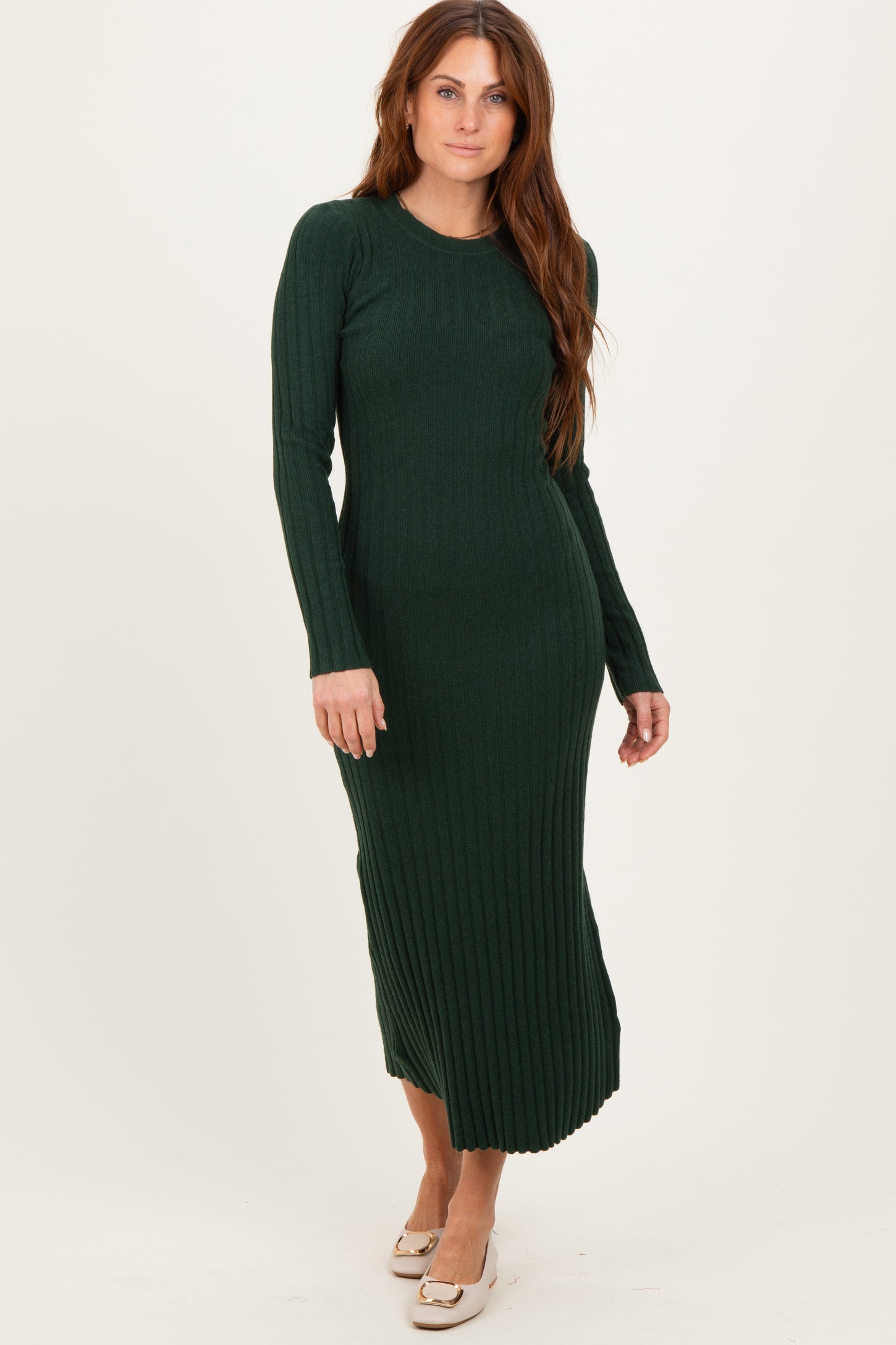 woman wearing a long green ribbed knit dress with long sleeves and a fitted silhouette