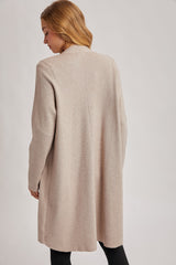 woman wearing a beige longline cardigan with a relaxed fit, seen from the back