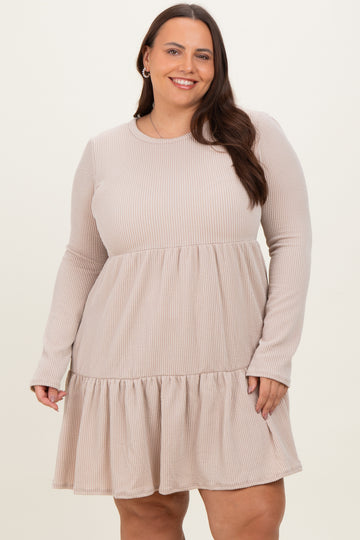 woman wearing a beige ribbed long sleeve plus size dress with a ruffled hem and a relaxed fit