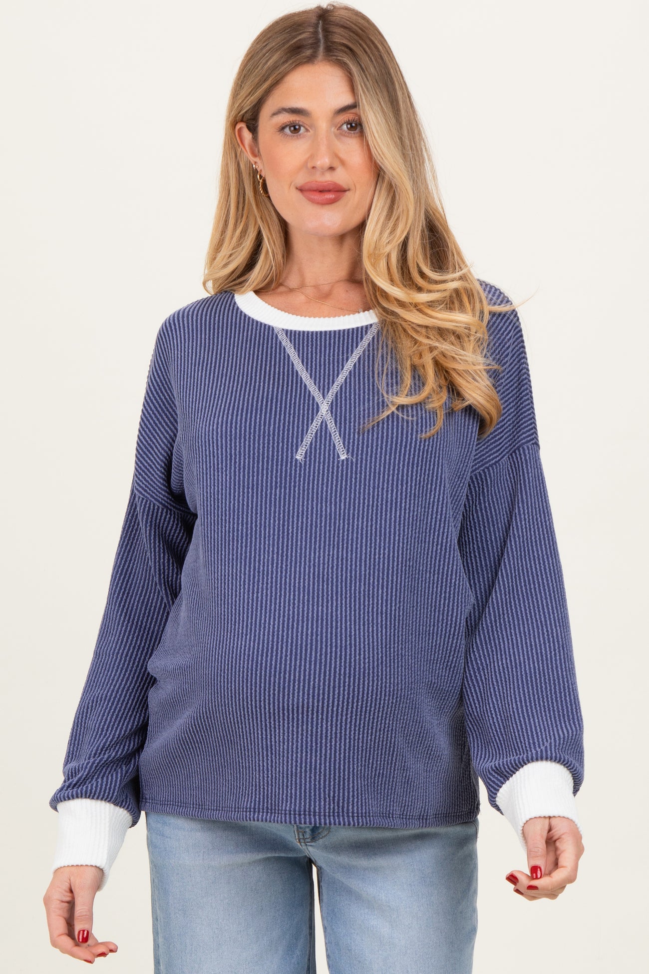 woman wearing a navy and white striped maternity sweater with long sleeves and a relaxed fit, showcasing her baby bump