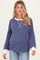 woman wearing a navy and white striped maternity sweater with long sleeves and a relaxed fit, showcasing her baby bump