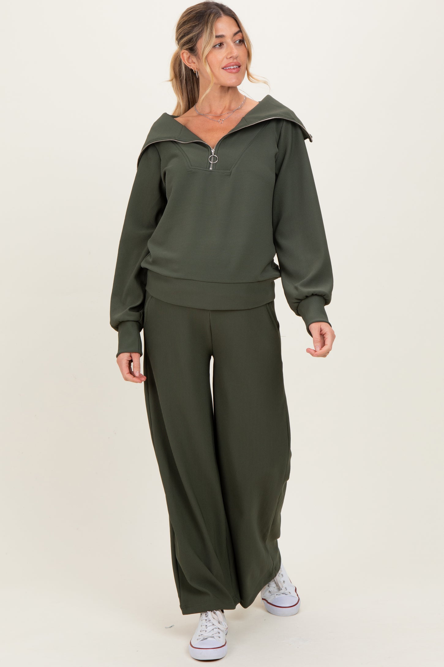 woman wearing an olive green maternity hoodie with zip and matching wide-leg pants
