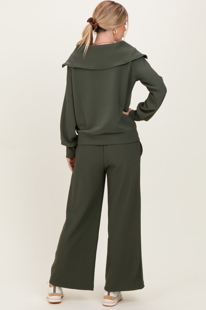 woman wearing a green ribbed lounge set with an oversized collar and wide-leg pants, viewed from the back