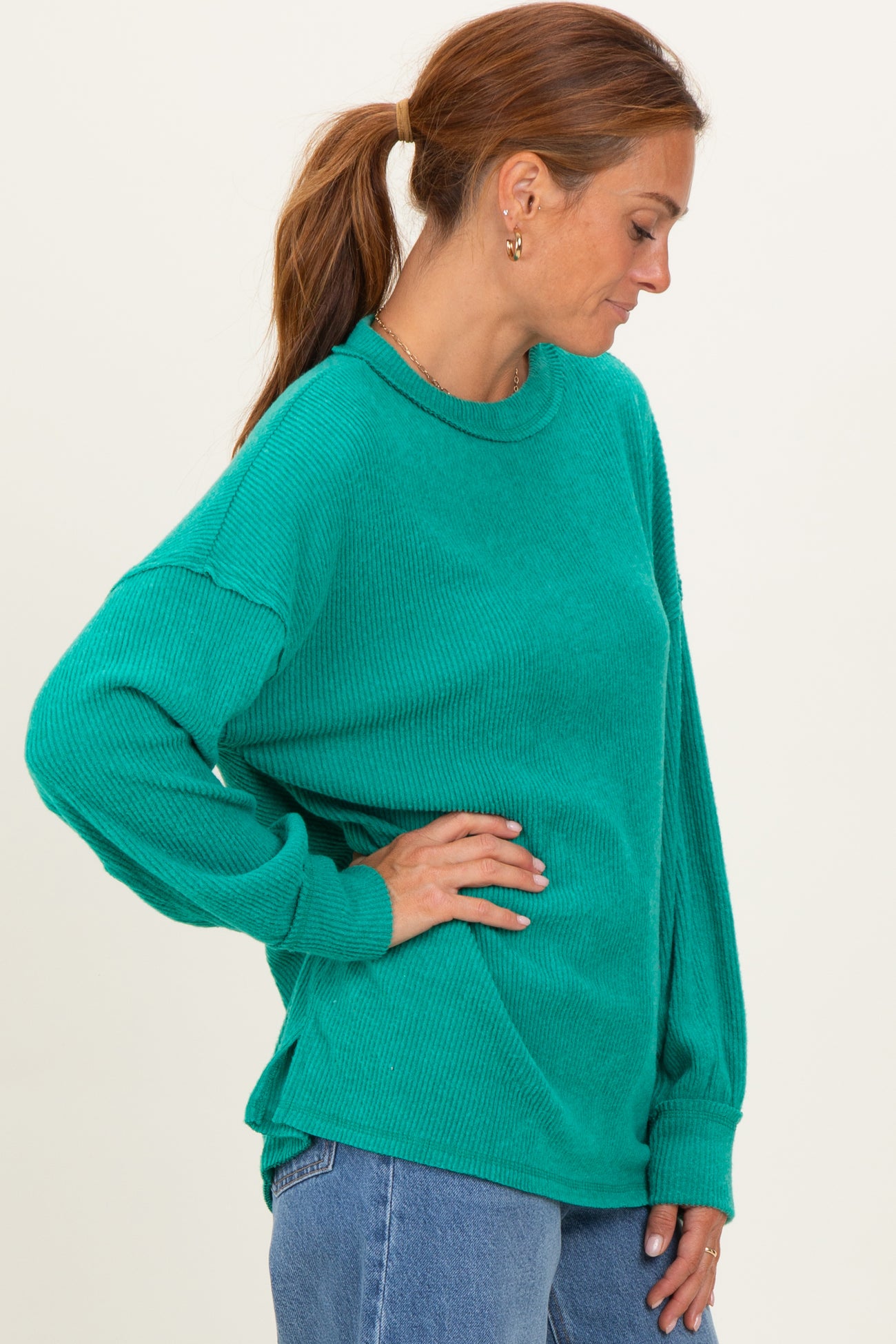 woman wearing a teal ribbed long sleeve oversized sweater with dropped shoulders and relaxed fit