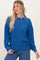 woman wearing a blue ribbed long sleeve top with a relaxed fit and rolled sleeves, paired with jeans