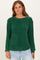 woman wearing a green long sleeve textured sweater with a relaxed fit and round neckline