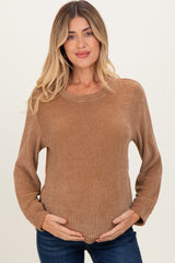 woman wearing a brown long sleeve maternity sweater and holding her baby bump