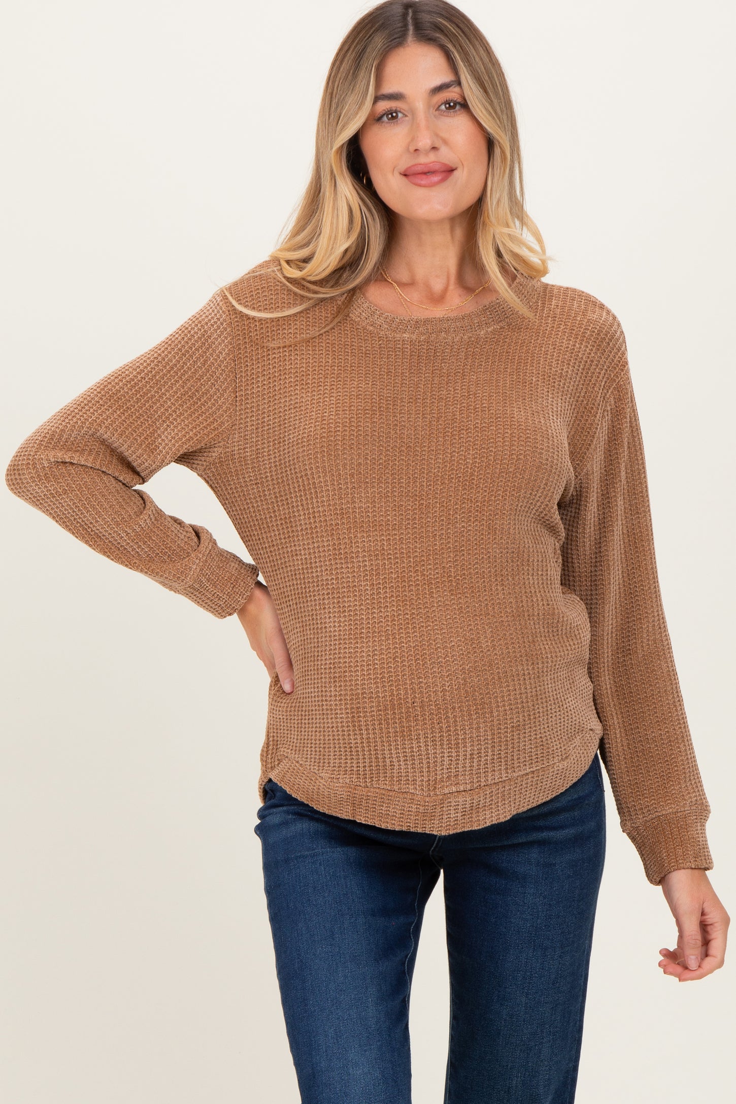 woman wearing a brown long sleeve maternity top with a relaxed fit and rounded hem, showcasing her baby bump