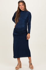 woman wearing a navy blue long sleeve maternity dress with ruching and a side slit, showing her baby bump