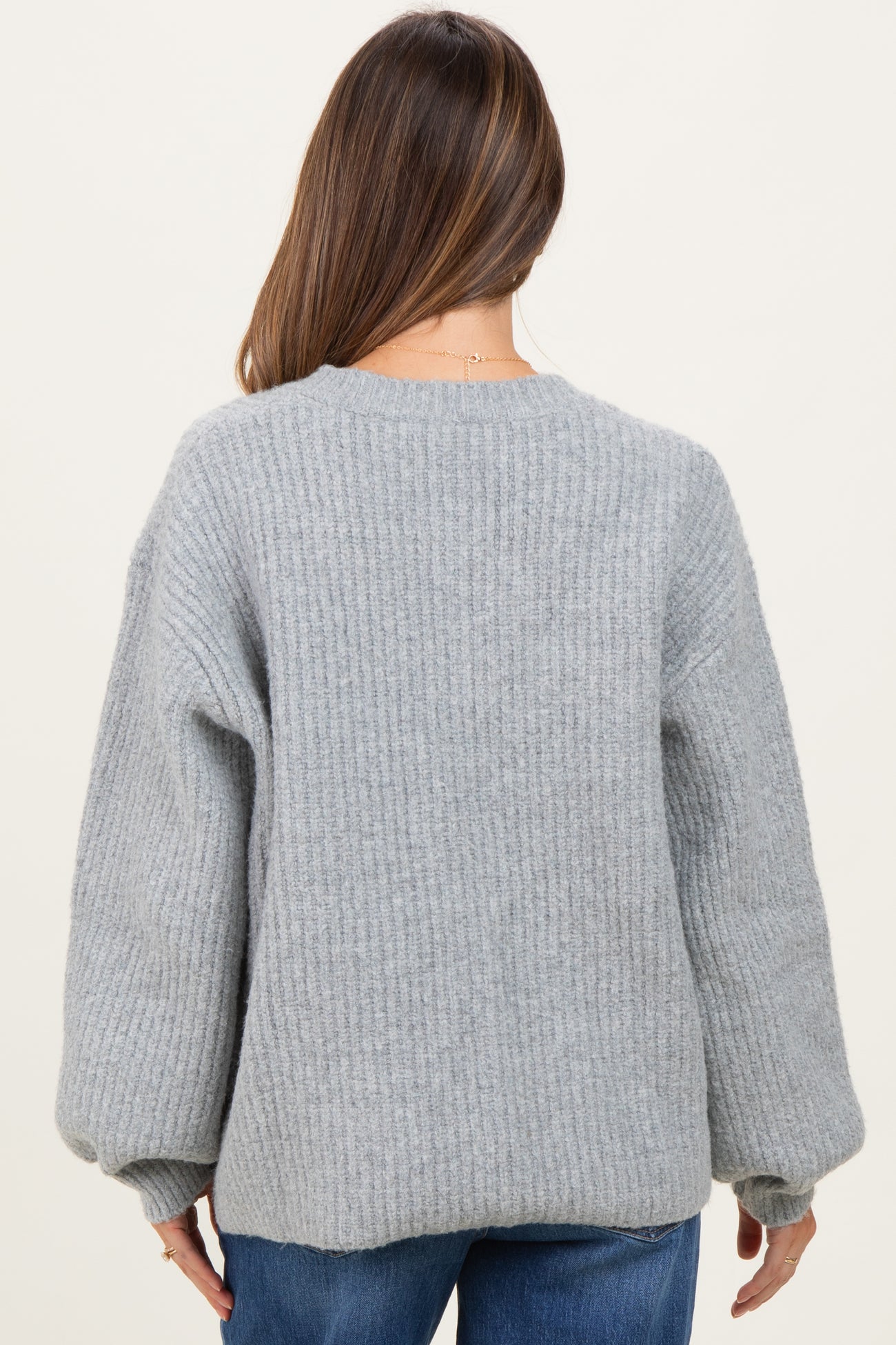 woman wearing a gray ribbed maternity sweater with balloon sleeves seen from the back