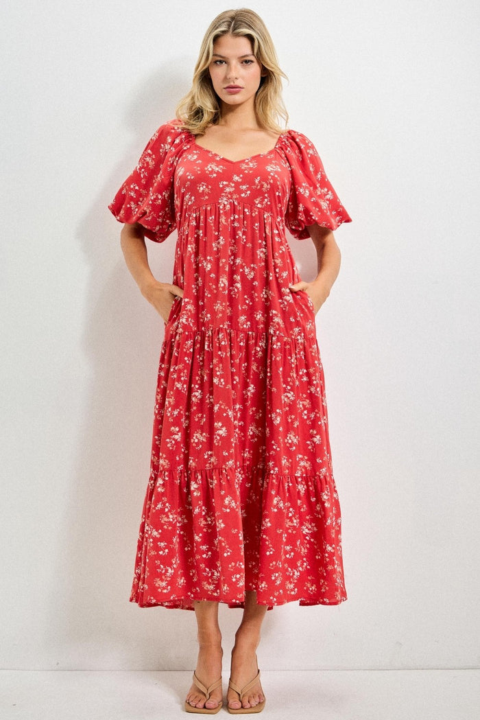 woman wearing a red floral midi dress with puff sleeves and pockets