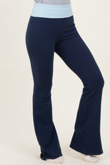 woman wearing navy blue flared yoga pants with a light blue waistband