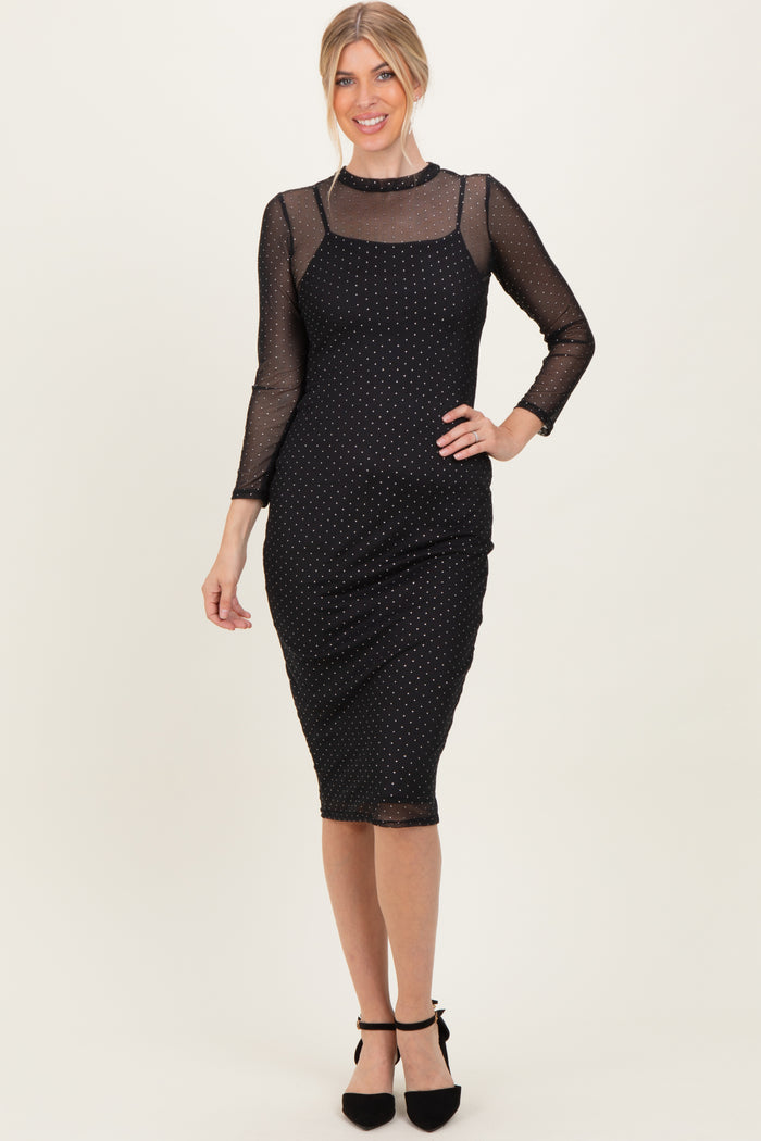 woman wearing a black polka dot midi dress with sheer long sleeves and a fitted silhouette