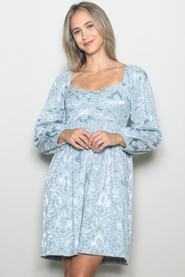 woman wearing a light blue floral print mini dress with puff sleeves and a square neckline