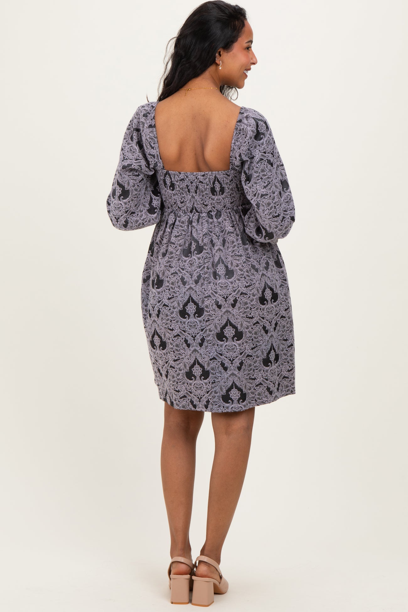 woman wearing a black and gray patterned maternity dress with puff sleeves and a square back