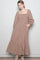 woman wearing a brown checkered long sleeve maxi dress with a smocked bodice and tiered ruffle hem, posing with hands in pockets