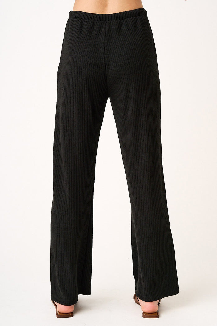 black ribbed wide leg pants with a comfortable waistband, shown from the back