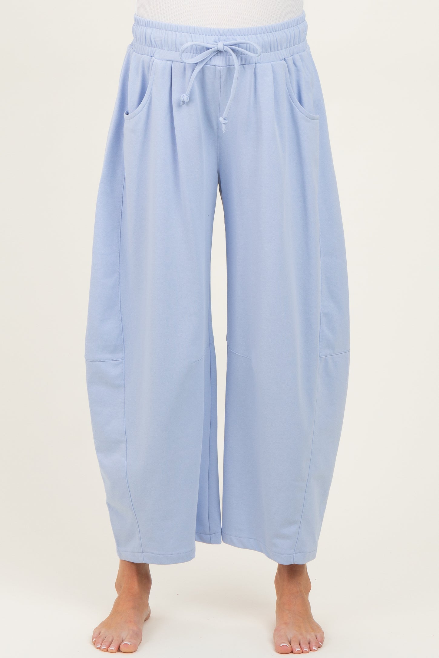 woman wearing light blue maternity wide-leg lounge pants with pockets and adjustable drawstring waist