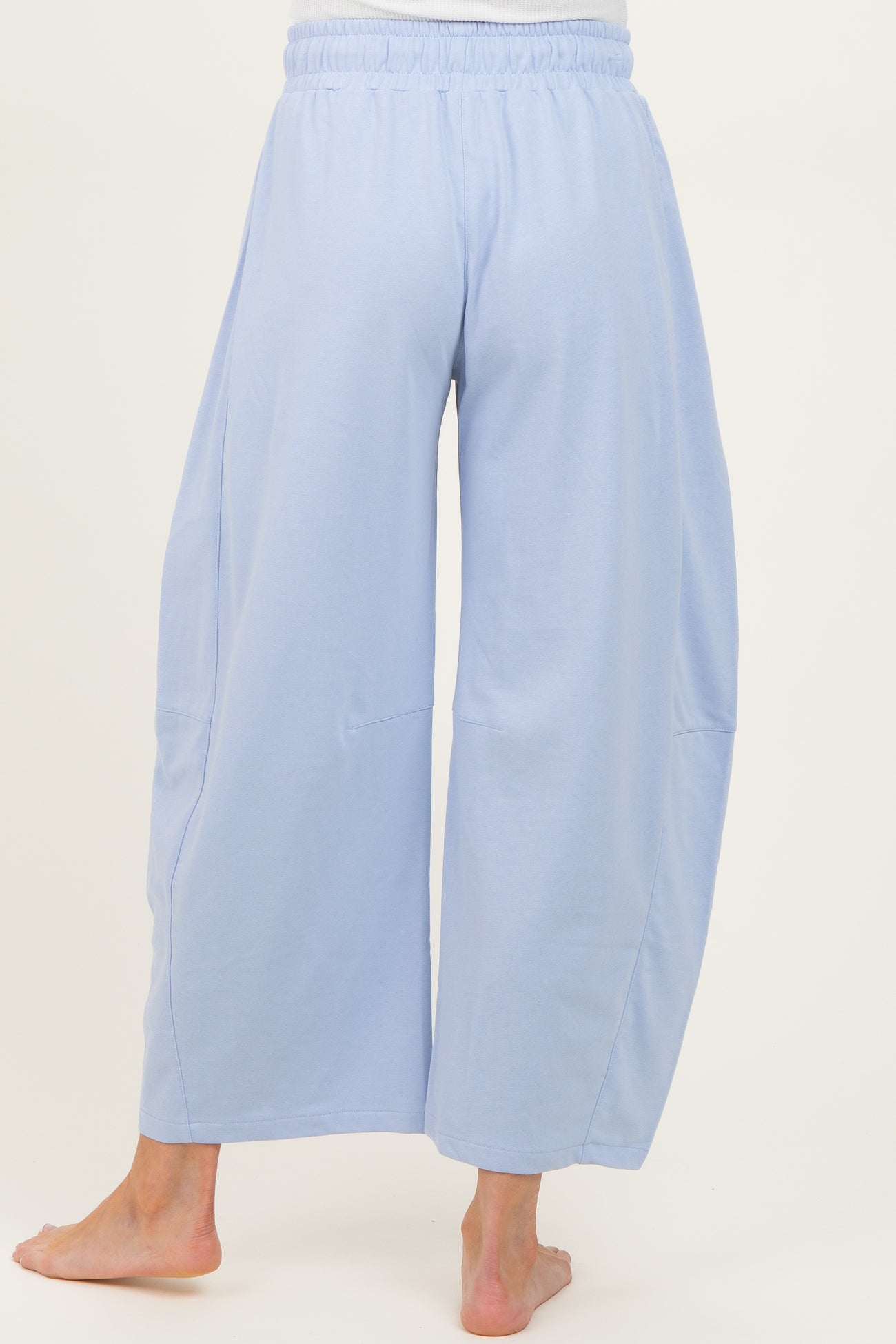 woman wearing light blue maternity wide-leg pants, showing the back view with an elastic waistband and relaxed fit
