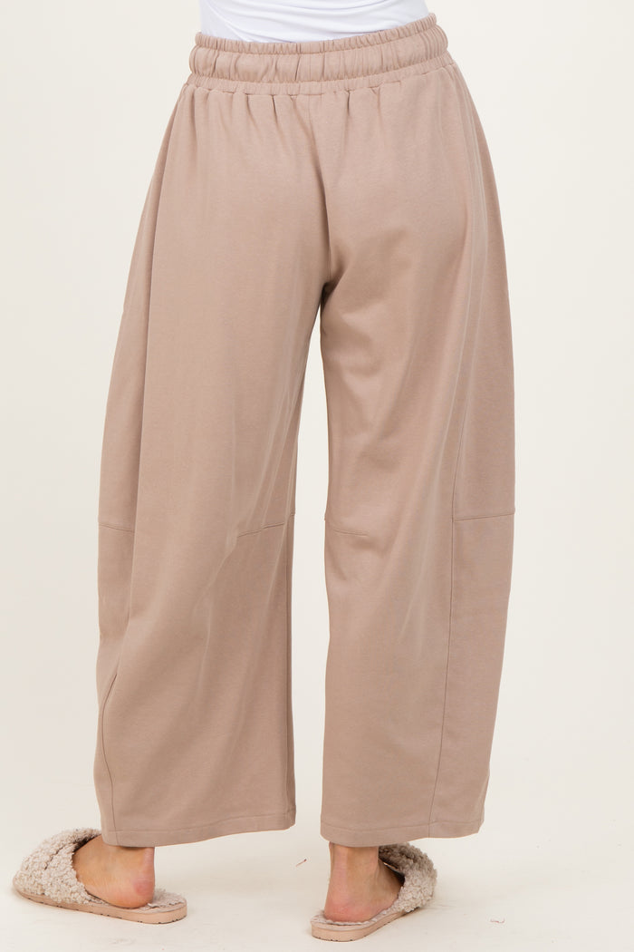 woman wearing beige wide-leg lounge pants with an elastic waistband and side seam details