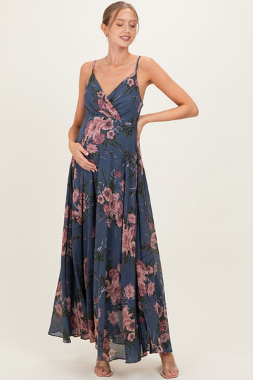 woman wearing a navy blue floral maternity dress with a v-neck and flowing skirt, showcasing her baby bump