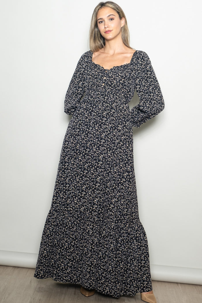 woman wearing a navy floral long sleeve maxi dress with a square neckline and button details