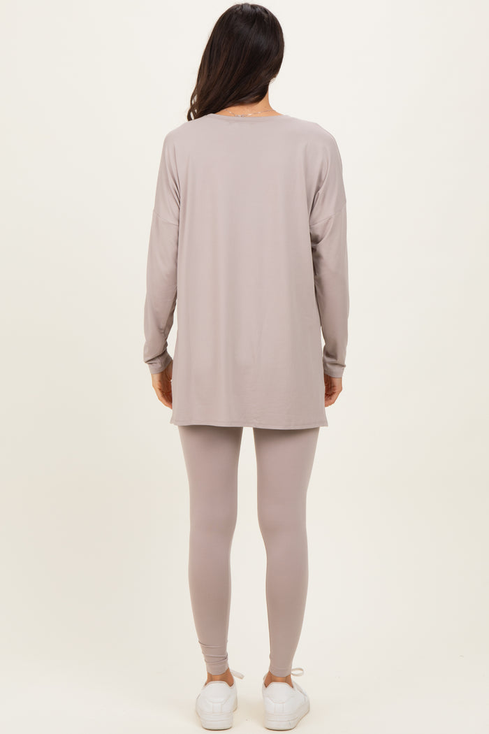 woman wearing a long sleeve taupe tunic top and matching leggings, paired with white sneakers, standing with back to the camera