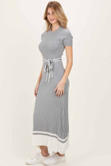 woman wearing a gray ribbed maxi dress with short sleeves and a tie waist detail, styled with white sneakers