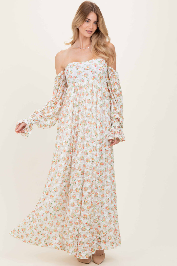 woman wearing a floral off-the-shoulder maxi dress with long puff sleeves and a flowing skirt