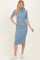 woman wearing a ribbed blue midi dress with short sleeves and a high neckline, paired with white sneakers