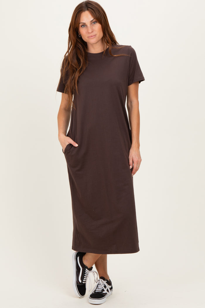 woman wearing a dark brown short sleeve maxi dress with pockets and black sneakers