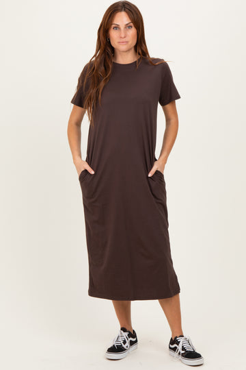 woman wearing a dark brown short sleeve midi dress with side pockets and casual sneakers