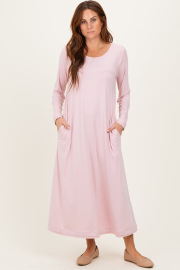 woman wearing a light pink long sleeve maxi dress with side pockets