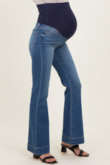 woman wearing blue maternity bootcut jeans with a navy belly panel and showing her baby bump