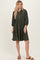 woman wearing an olive green button-up tiered dress with long sleeves and a relaxed fit